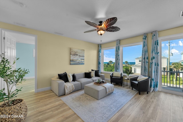 living room with a wealth of natural light, ceiling fan, and light hardwood / wood-style flooring