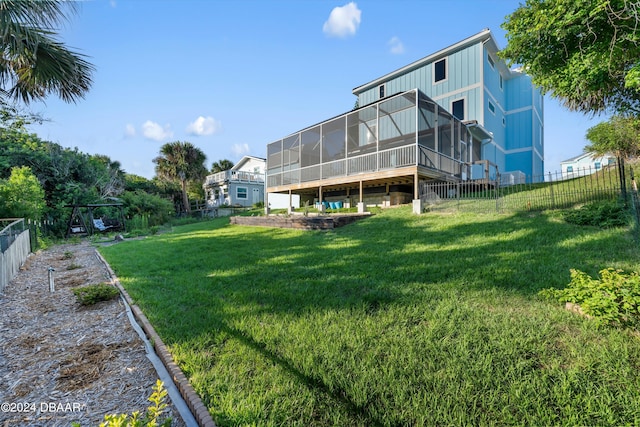 back of property with a lawn and a sunroom