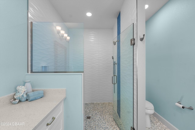 bathroom with toilet, vanity, tile patterned flooring, and a shower with door