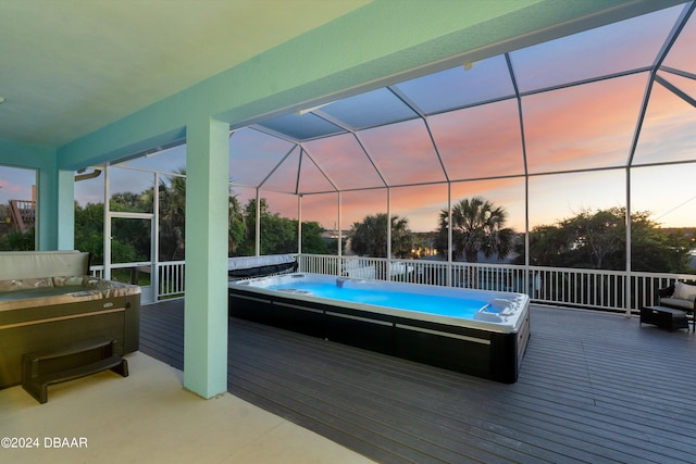 pool at dusk with a lanai and a wooden deck