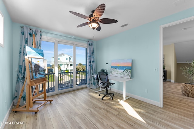 office with light hardwood / wood-style flooring and ceiling fan