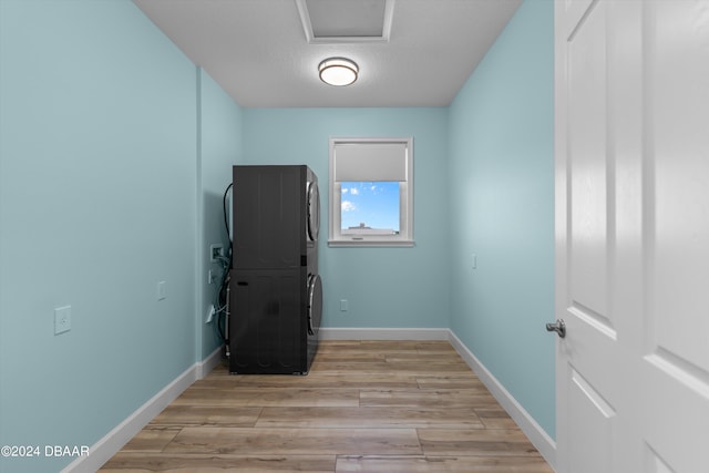 interior space featuring a textured ceiling, stacked washer / dryer, and light wood-type flooring