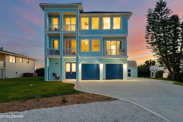 view of front facade with a garage, a yard, and a balcony