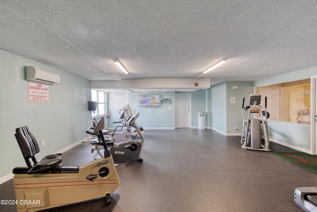 workout area featuring a wall mounted AC and a textured ceiling