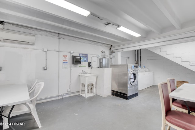 basement featuring sink, electric water heater, a wall mounted AC, and washing machine and clothes dryer