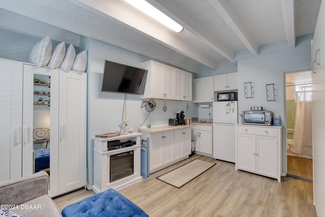 kitchen featuring beam ceiling, white fridge, white cabinetry, and light hardwood / wood-style floors