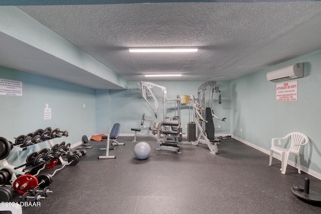 exercise room with a textured ceiling and an AC wall unit