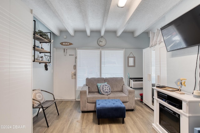 living room featuring beamed ceiling, plenty of natural light, light hardwood / wood-style floors, and a textured ceiling