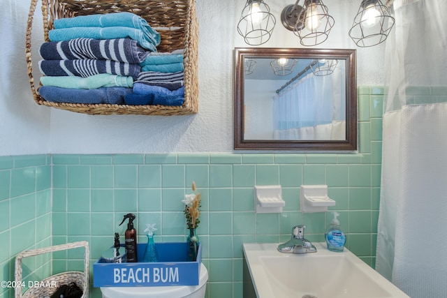 bathroom featuring tile walls and sink