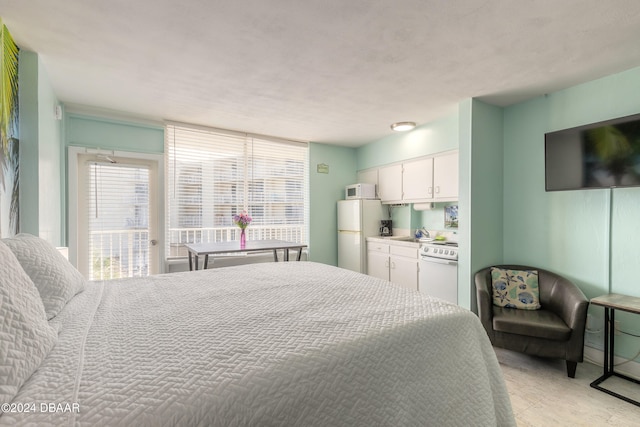 bedroom featuring white refrigerator and sink