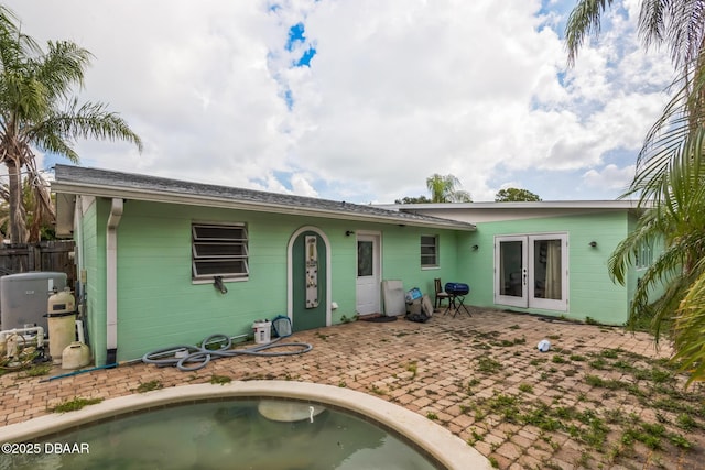 225 Sherwood Ln, Daytona Beach, FL 32117 - rear view of house with french doors, concrete block siding, a patio, and an outdoor pool