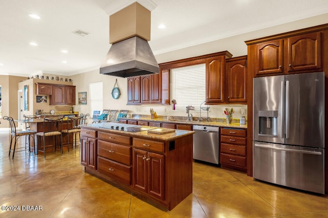 kitchen with island exhaust hood, appliances with stainless steel finishes, light stone countertops, ornamental molding, and a kitchen island