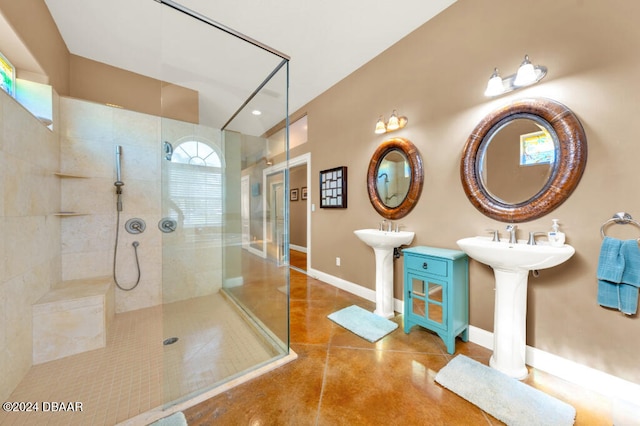 bathroom featuring double sink and tiled shower