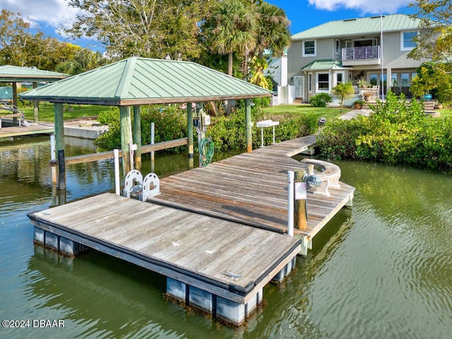 dock area with a water view and a balcony