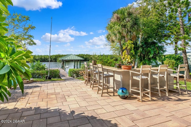 view of patio / terrace with a water view and a bar