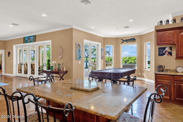 kitchen with light tile patterned flooring, a wealth of natural light, crown molding, and billiards