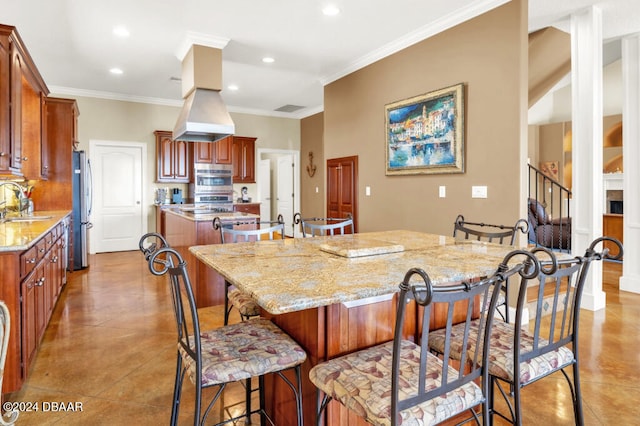 kitchen with light stone counters, a kitchen island, crown molding, and sink