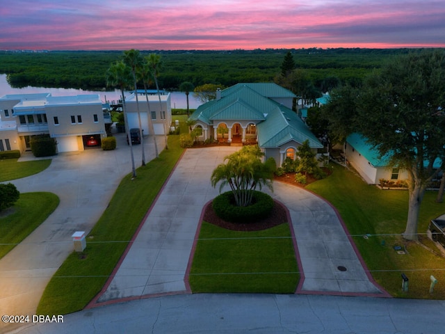 aerial view at dusk featuring a water view