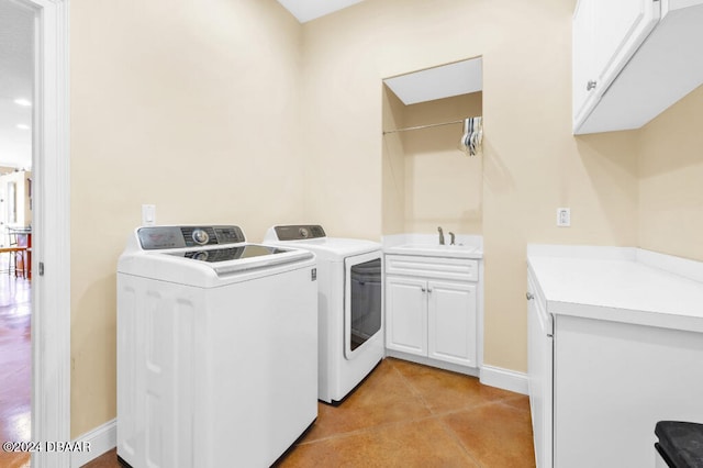 washroom with cabinets, independent washer and dryer, light tile patterned flooring, and sink