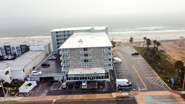 drone / aerial view featuring a water view and a view of the beach