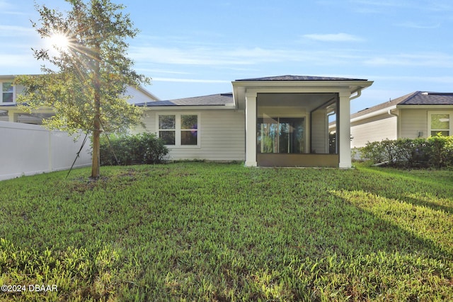 rear view of property featuring a lawn