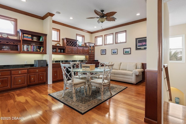 dining space featuring crown molding, a ceiling fan, and plenty of natural light