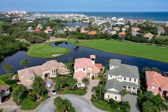 drone / aerial view featuring a water view, view of golf course, and a residential view