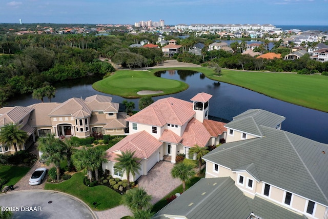 drone / aerial view with golf course view, a residential view, and a water view