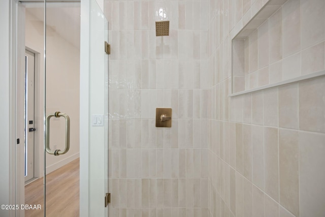 bathroom with an enclosed shower and hardwood / wood-style flooring