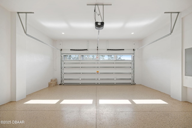 garage with a garage door opener and electric panel