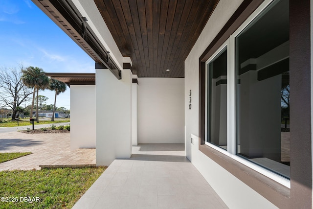 view of exterior entry with a patio area