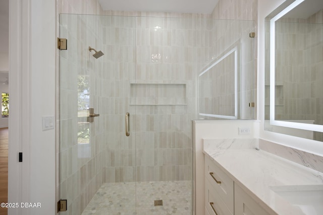 bathroom featuring vanity and a shower with door