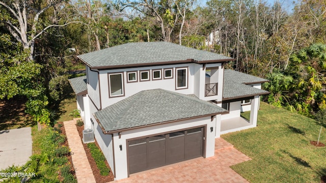 view of front of home with a garage, a front yard, and central air condition unit