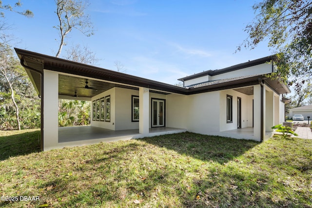 back of house featuring ceiling fan, a patio, and a lawn