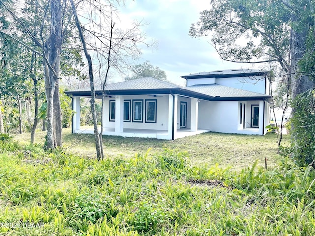 rear view of property featuring a patio area and a lawn