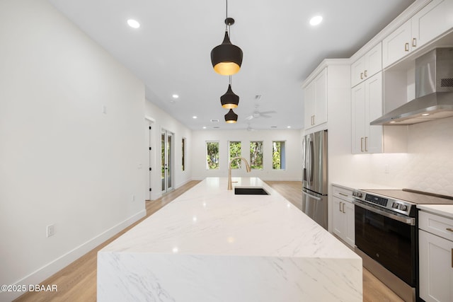 kitchen featuring an island with sink, appliances with stainless steel finishes, and pendant lighting