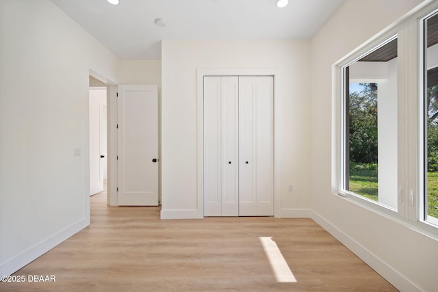 unfurnished bedroom featuring a closet and light wood-type flooring