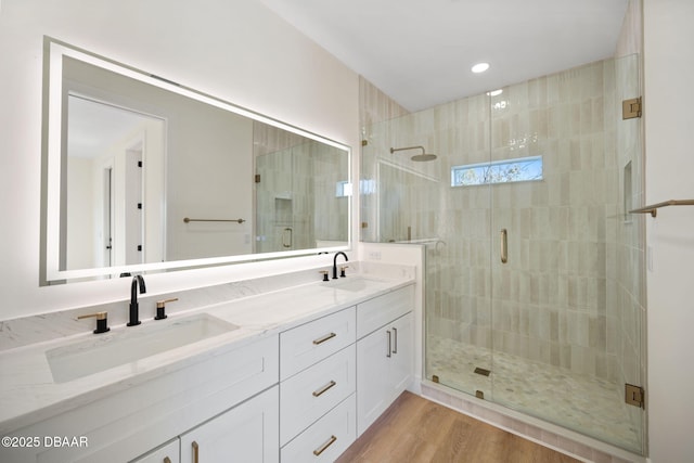 bathroom featuring vanity, wood-type flooring, and walk in shower