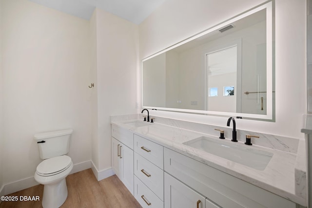 bathroom with wood-type flooring, vanity, and toilet