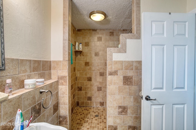 bathroom featuring tile walls, a textured ceiling, and tiled shower