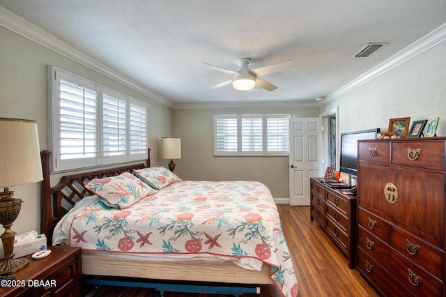 bedroom with crown molding, wood-type flooring, a textured ceiling, and ceiling fan