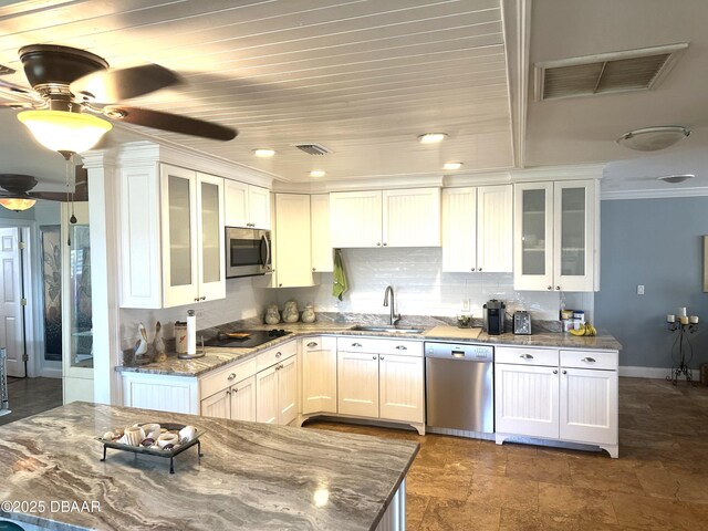 kitchen with white cabinetry, a breakfast bar area, tasteful backsplash, and appliances with stainless steel finishes