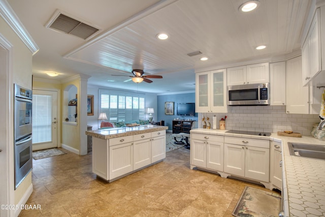 kitchen with white cabinetry, appliances with stainless steel finishes, sink, and backsplash