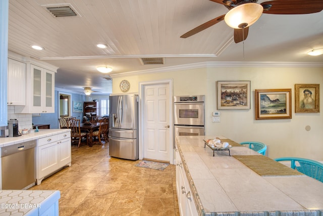 kitchen with white cabinetry, wood ceiling, crown molding, ceiling fan, and stainless steel appliances