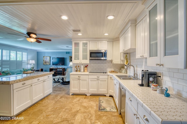 kitchen with appliances with stainless steel finishes, sink, decorative backsplash, and white cabinets