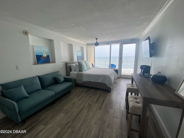 bedroom featuring access to exterior, a textured ceiling, dark hardwood / wood-style floors, and crown molding