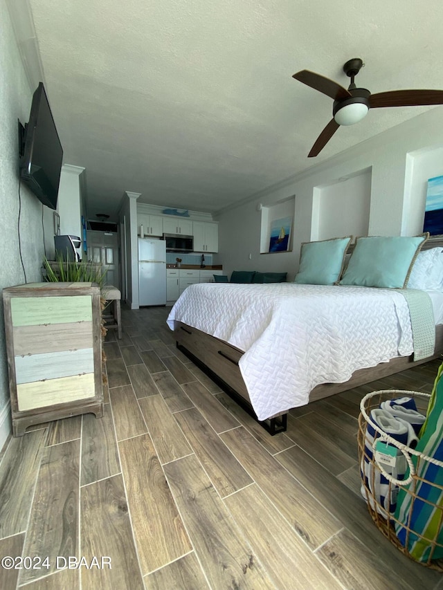 bedroom with dark wood-type flooring, ceiling fan, and white refrigerator