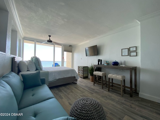 bedroom featuring dark hardwood / wood-style flooring, ornamental molding, a textured ceiling, and ceiling fan