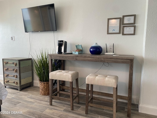 bar with hardwood / wood-style floors