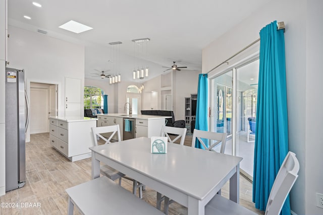 dining space with a skylight, a wealth of natural light, sink, and ceiling fan